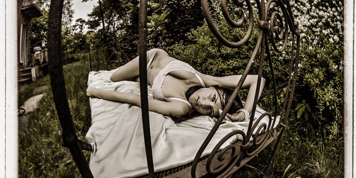 Kobieta w koronkowej bieliźnie na stalowym łóżku - sesja sensualna