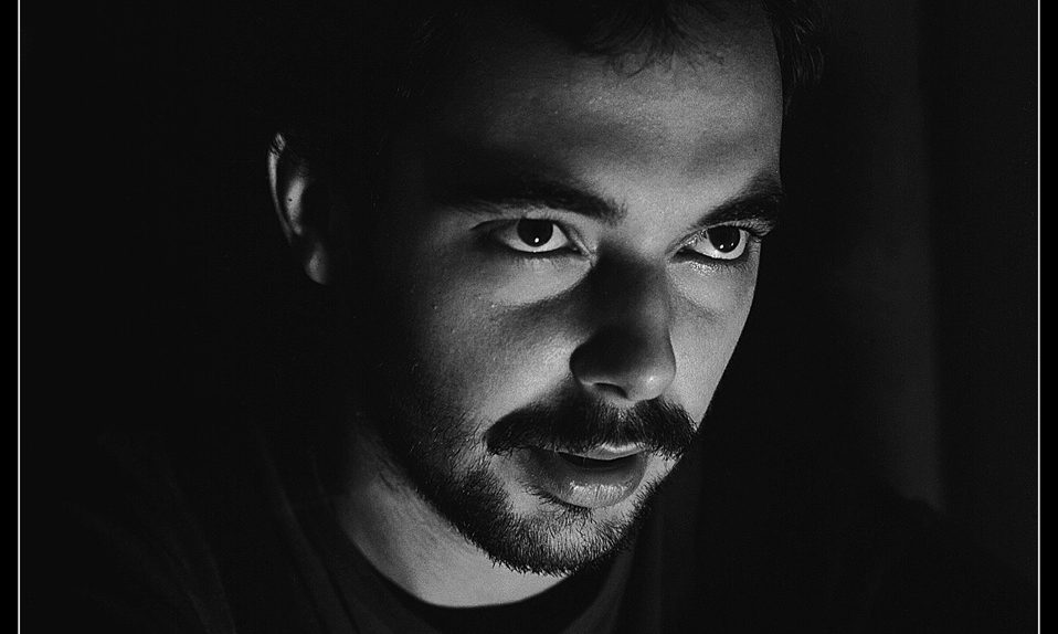 portret męski w prostym świetle na czarnym tle